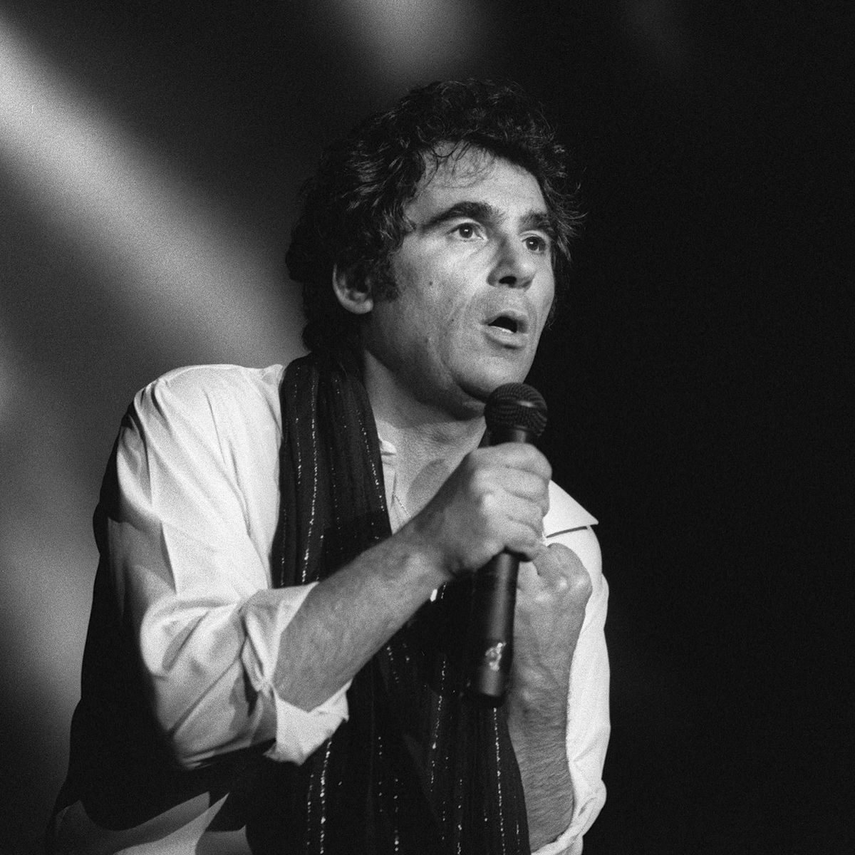 Le chanteur français Claude Nougaro sur la scène du Palais des Sports de Toulouse, le 23  février 1983. (JEAN-PIERRE MULLER / AFP)